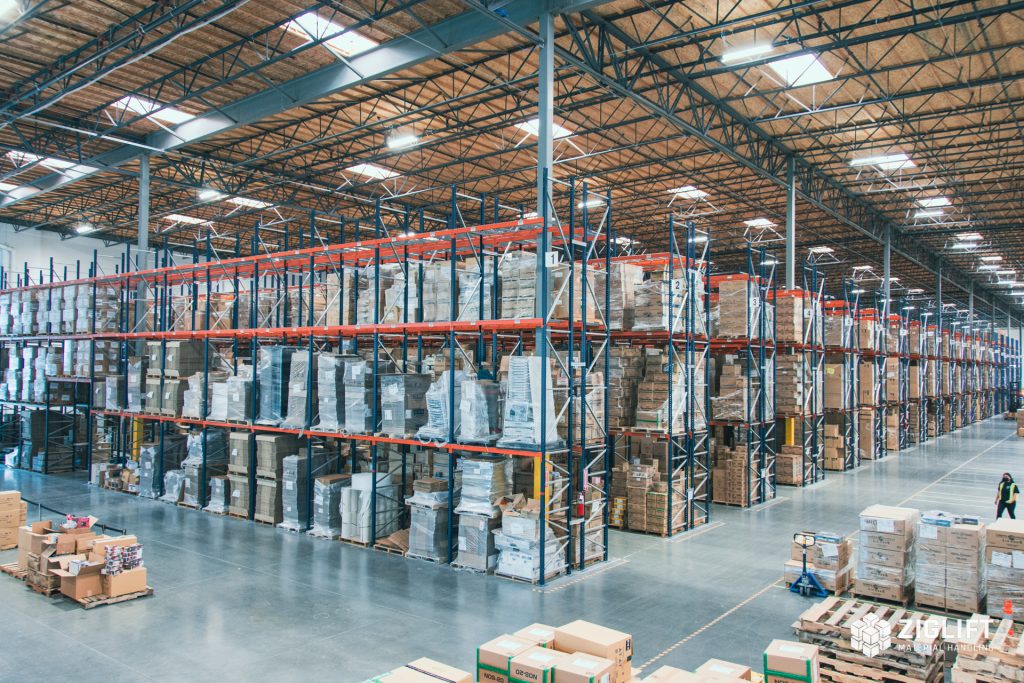 Rows of selective pallet rack with orange beams in a distribution warehouse
